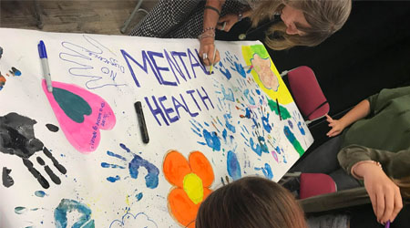 Young people working with an organisation to create a painted mental health banner